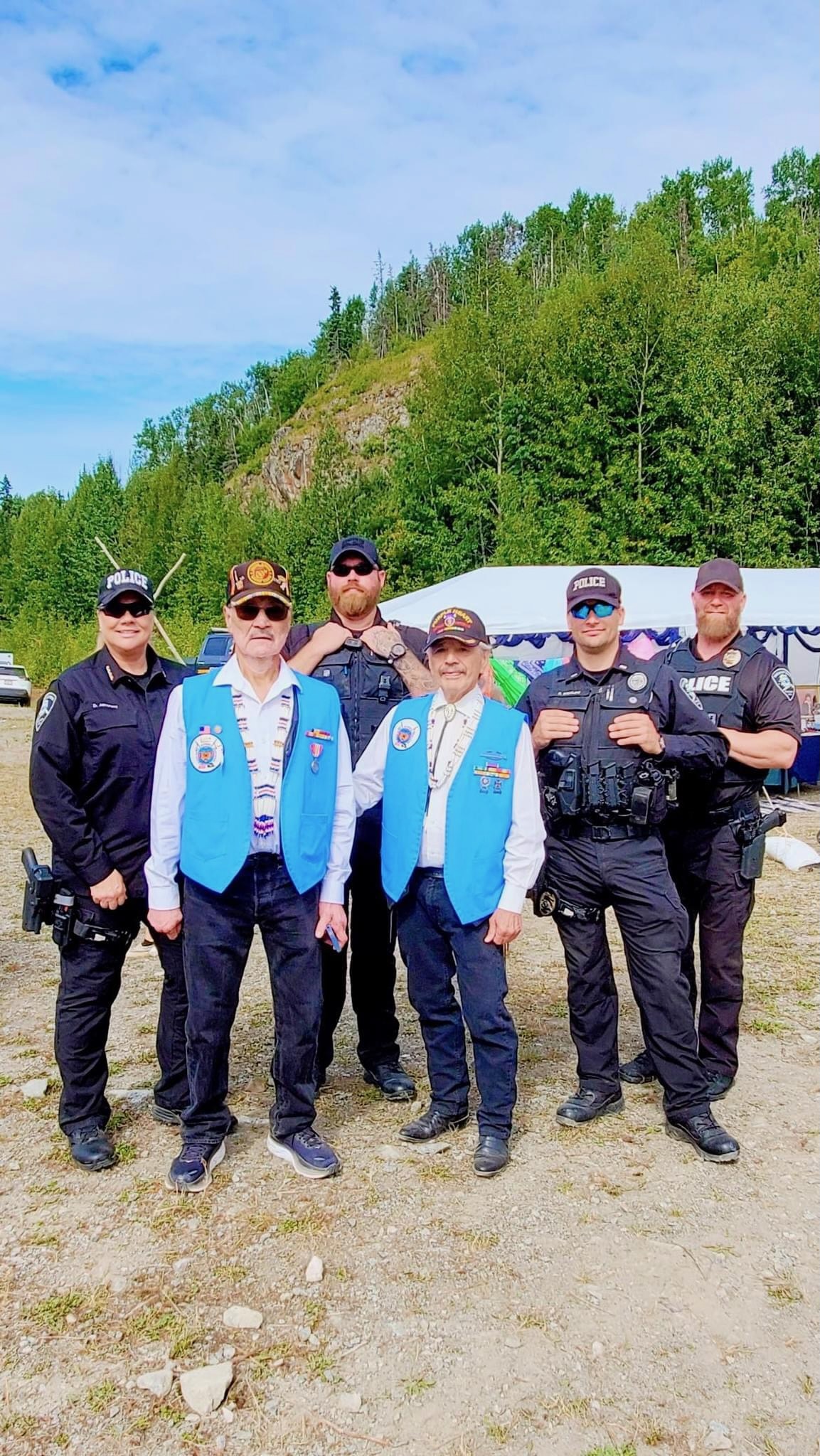 Eklutna Veteran Elders standing alongside Chickaloon Village Tribal Police Officers at the 2024 Eklutna Powwow. Photo courtesy of Philip Ling, Chickaloon Tribal Court Director