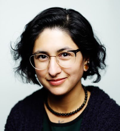 Gabriela Zapata-Alma wearing a black tshirt and black-rimmed glasses, with black, short hair. 