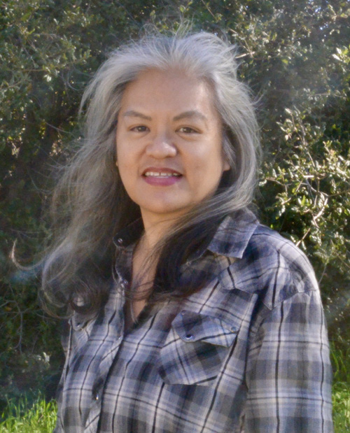 Headshot of Paula Julian with green leaves in background