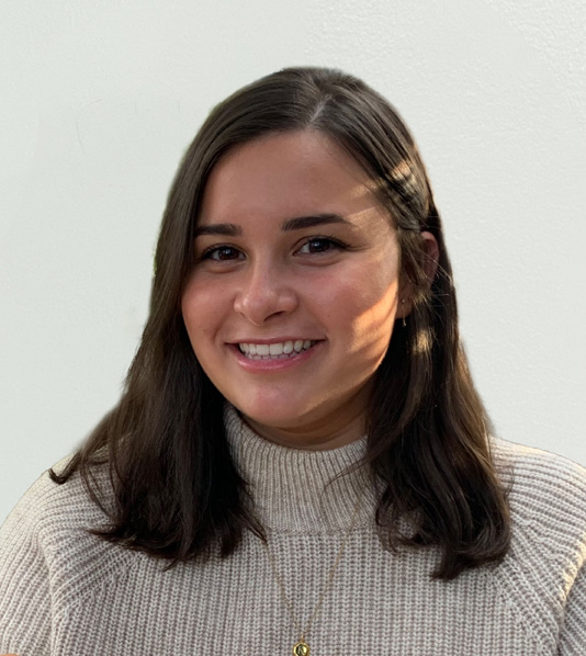 Headshot of Kerri Colfer in white sweater with white background.