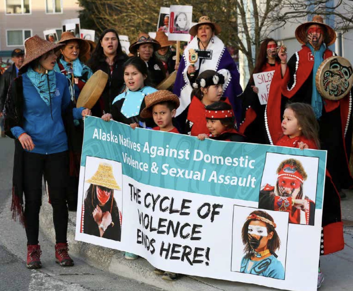 Photo of group of protesters (4 children in front) holding banner that says "The Cycle of Violence Ends Here!"