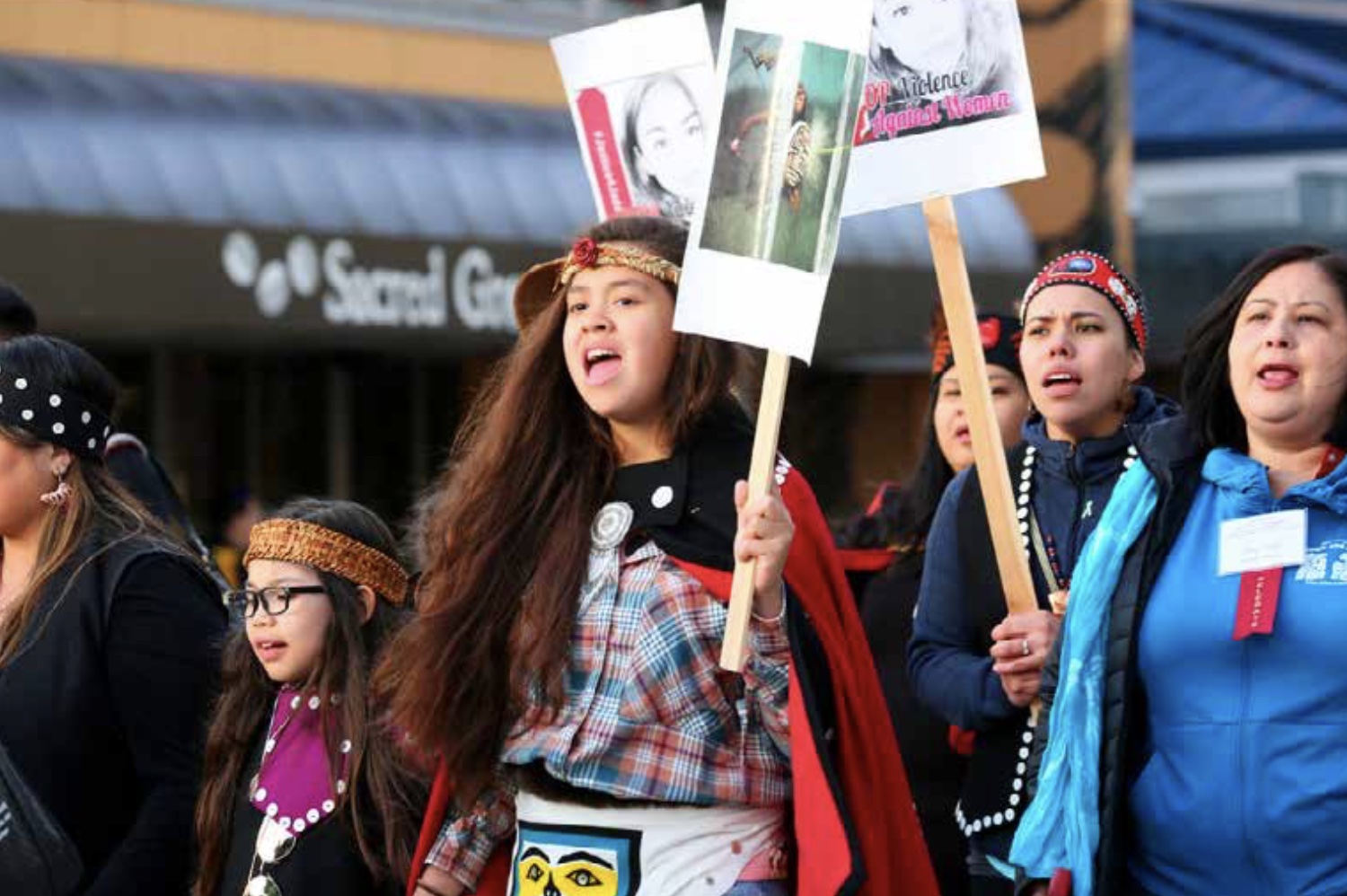 Group of women and girls protesting, holding up sgns