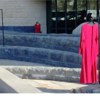 Long red dresses on metal hook scattered on ascending concrete stairway